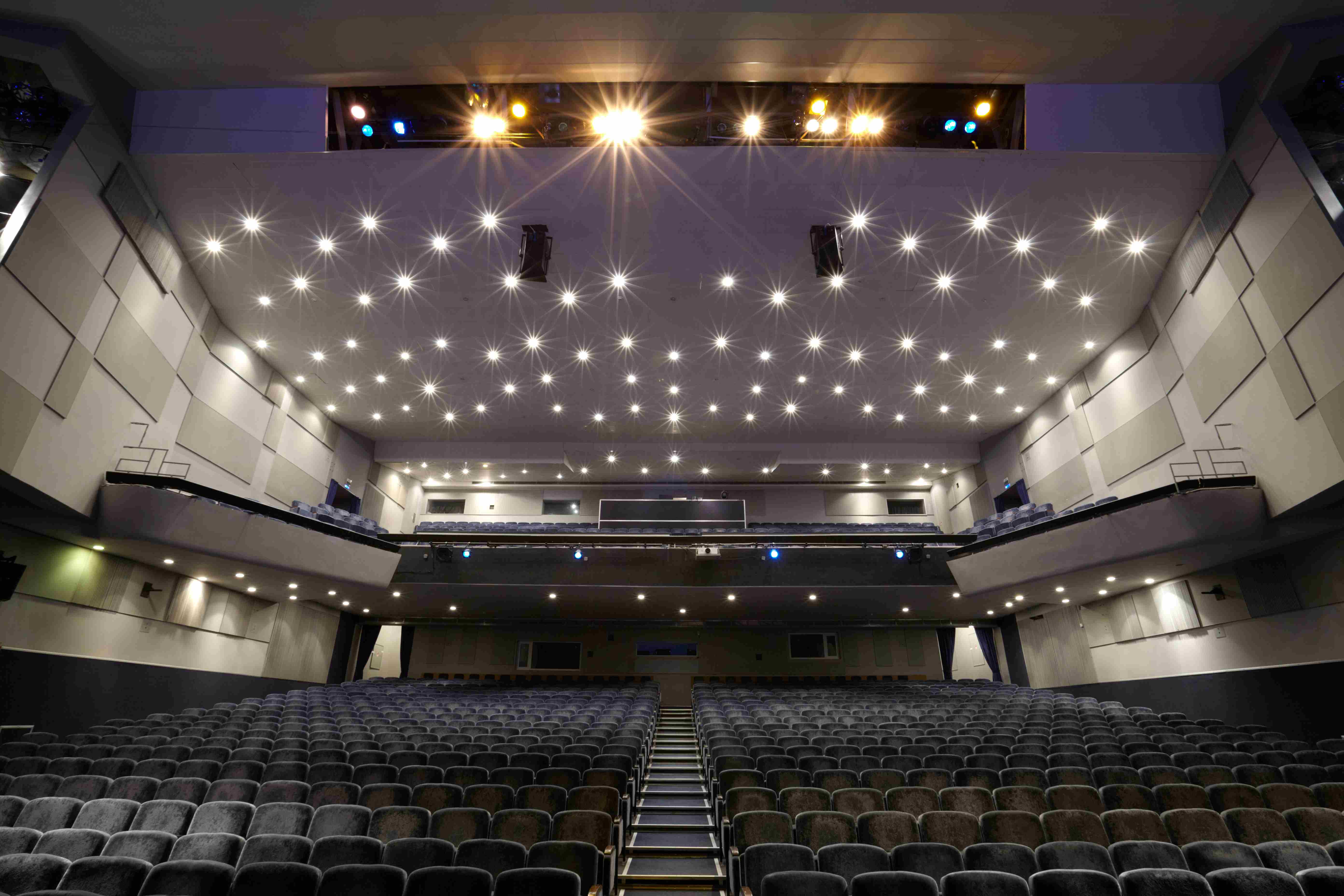 Interior of empty cinema auditorium with lines of chairs.